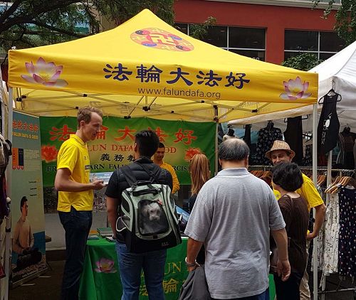 图1-2:法轮功学员在纽约曼哈顿下城举办的富尔顿街(Fulton Street)集市上介绍功法