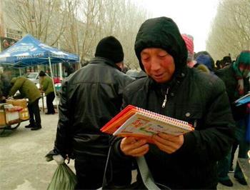 '图31:在寒冷的冬天,在早市、在路旁,有缘人得到大法弟子做的挂历很欣慰(二零一五年视频截图)'