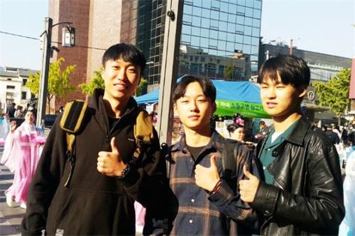 '图8:来首尔旅行偶遇游行队伍的韩国大学生朴贤镇(音译,中间)和他的朋友们。'