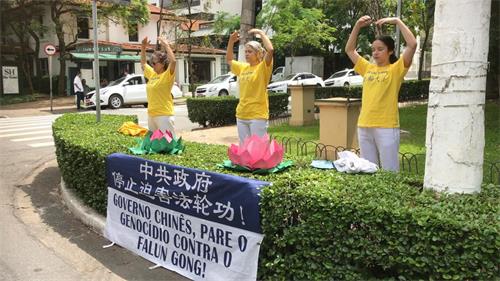 '图1:法轮功学员在中领馆前炼功,讲真相,抗议中共迫害。'