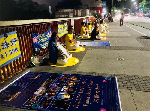 '图4:法轮功学员在自由大道上点燃蜡烛,肃穆静坐,悼念被中共迫害致死的中国法轮功学员。'