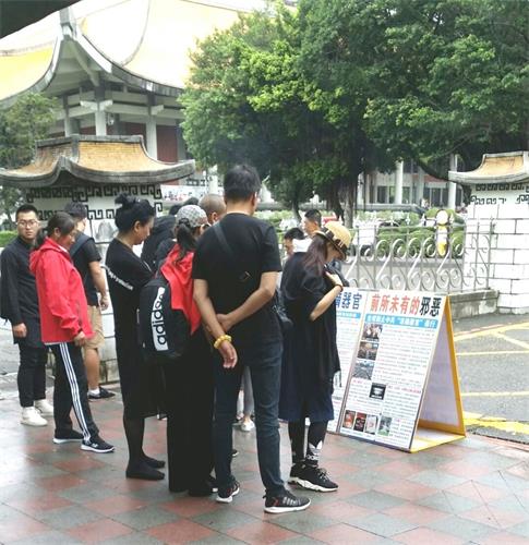 '图1~4:台北国父纪念馆前,大陆游客认真阅读法轮功真相展板'