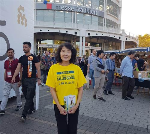 '图5:法轮功学员陈女士在书展期间给中国人讲真相,劝“三退”。'
