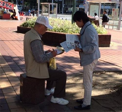 '图1~3:法轮功学员在名古屋市中心向民众讲真相,征签谴责中共迫害。'