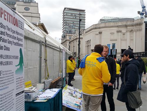 图6:二零一八年十月二十七日,法轮功学员本(Ben)在特拉法加(Trafalgar Square)广场向在伦敦工作的奥利佛(Oliva)和弗拉维奥(Flavio)深入讲真相