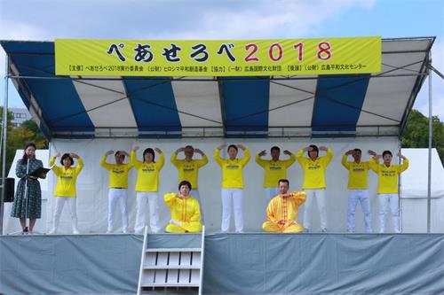 '图2:法轮功学员在和平与爱国际交流节舞台上演示五套功法动作'