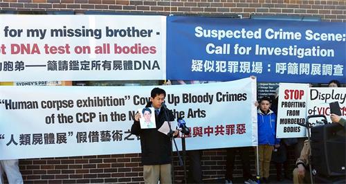 '图1:黄万青博士手举十五年前失踪的弟弟的照片'