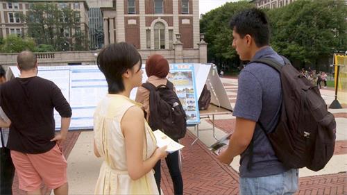 '图2:大法社团的学生向同学们讲法轮功在中国遭到迫害的真相'