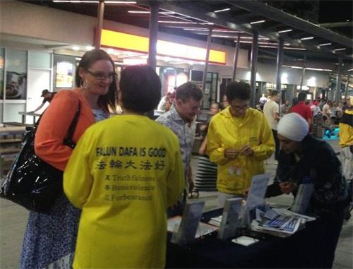'图1~2:人们驻足了解真相,签名支持法轮功反迫害'