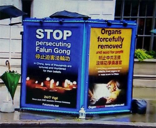 '图7:BBC播出镜头中出现法轮功学员在伦敦中使馆前坚持和平抗议的真相展板'
