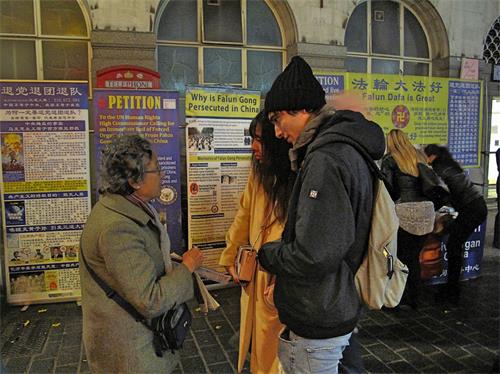 '图8:十一月十七日,两位意大利游客在伦敦唐人街第一次听说法轮功,了解真相后立即签名反迫害。'