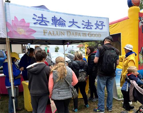 图1:巴拉瑞特举办的慈善市集上,法轮功展位吸引民众驻足。