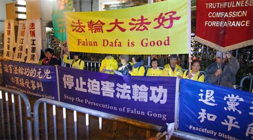 图14:约下午六点后,游行队伍抵达终点中联办,天国乐团继续在现场演奏一段时间,吸引更多民众围观,了解真相。