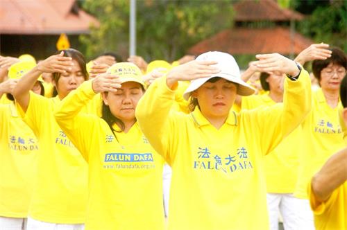'图1~3:二零一八年十二月八日,法轮功学员在马来西亚法会召开前夕,举行集体炼功,场面祥和壮观。'