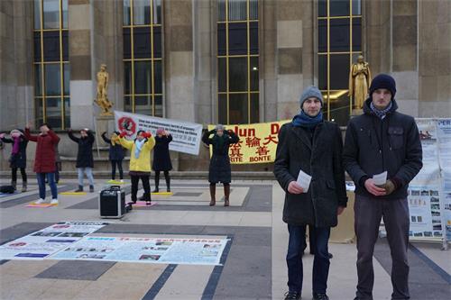 '图4:Guillaume(左)和Axel是一对表兄弟,他们满怀喜悦之情向游客介绍法轮功'