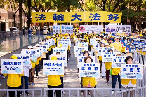 '图2:法轮功学员手举标语,传递“法轮大法好、停止迫害法轮功、法办江泽民”等呼声。'