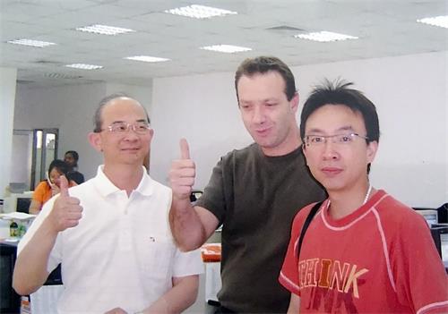 '图3:黄士坤(左)修炼大法之后,如期于二零零四年在赖索托建厂时,与来访的美国客户的合照。'