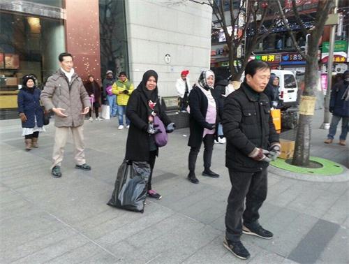 '图3:两位新加坡女士走进炼功队伍,兴奋地跟着一起学起炼功动作来'
