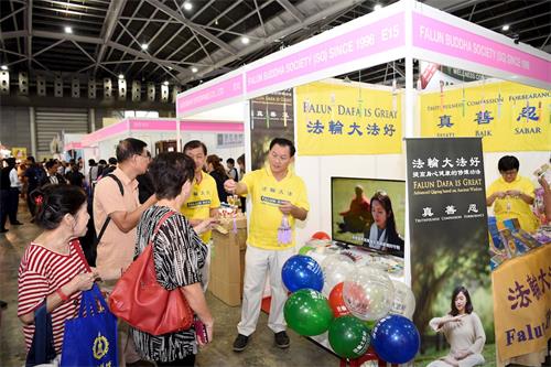 '图1:悬挂黄色“法轮大法好”横幅以及各种颜色的莲花手工挂坠的法轮功展位显得十分亮眼'
