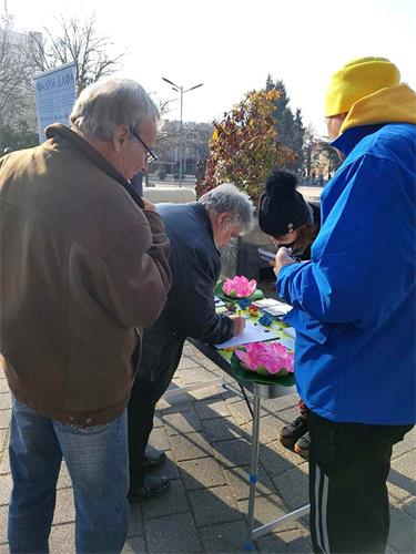 '图2:民众在要求法办江泽民的征签表上签名'