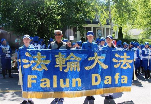 '图13:二零一七年六月三日的游行中,来自北京的游客表示,刚出来就遇上法轮功,一定要合影留念。'