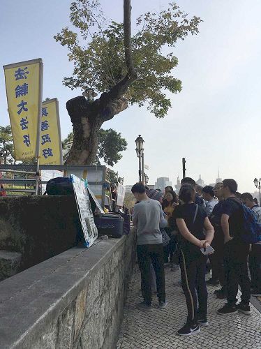 '图1~4:中国大陆游客在澳门景点认真阅读法轮功真相展板'