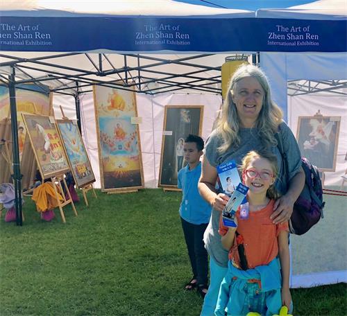 '图3:潘妮(Penny)和孙女潘吉(Paige)通过画展了解了法轮功被迫害的真相'