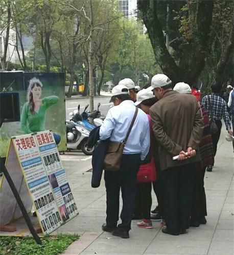 '图:大陆游客在台湾国父纪念馆前认真观看法轮功真相展板'