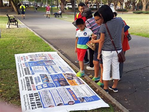 '图6:从中国来旅游的一家人一起看真相展板并一起退出中共组织'