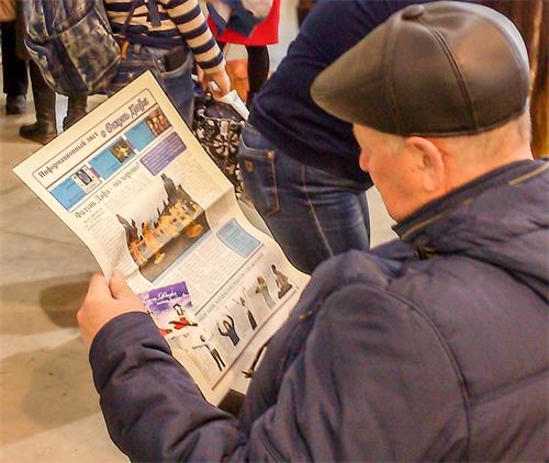 '图2:一民众在阅读介绍法轮功的报纸'