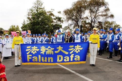 '图1:2018年4月1日星期天下午,一年一度复活节大游行开始前,本迪戈市长玛格丽特·奥罗克(Margaret O'Rourke)和法轮大法天国乐团的成员们合影。'