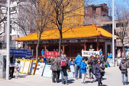'图2:2018年4月21日,加拿大蒙特利尔的部份法轮功学员纪念四二五万人和平上访十九周年,在唐人街中山公园举行集会和集体炼功,过往民众驻足了解真相。'