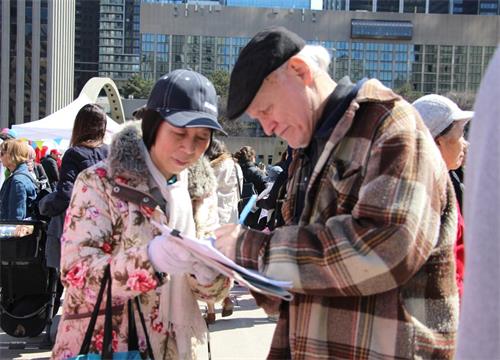 '图7:了解真相的民众在征签表上签名,制止迫害法轮功。'