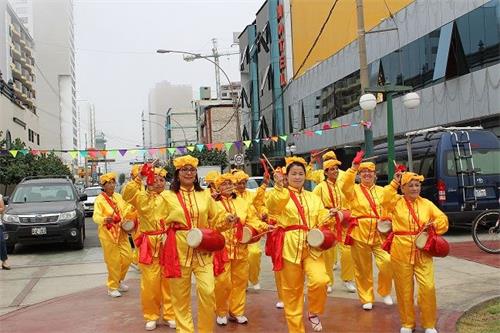 '图1~3:法轮功学员队伍从指定地点——自由广场出发,打开“法轮大法好”的横幅,敲着腰鼓,向图帕克阿马鲁广场行径,向沿途路人和商家传播法轮大法的美好。'