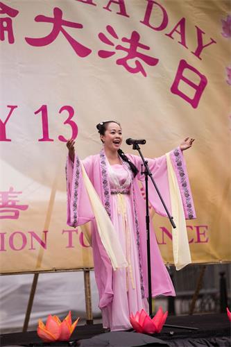 '图14:二零一八年五月十日,法轮功学员陈瑶在庆祝“第十九届世界法轮大法日”上表演女声独唱。'