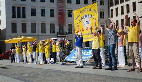 '图1:庆祝世界法轮大法日,柏林和部份莱比锡法轮功学员在柏林布兰登堡广场演示功法。'