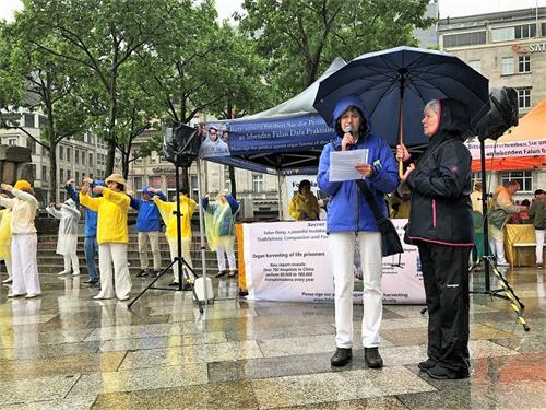 '图2:法轮功学员冒雨演示功法,向民众讲述法轮功的真相。'