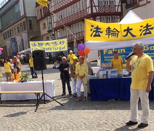 '图5:卡斯藤(右一)在活动现场上介绍法轮功。'