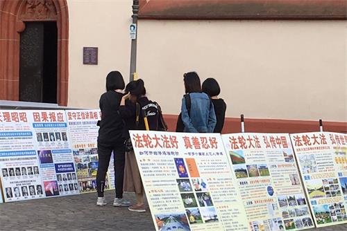 '图7:在真相展板前仔细阅读的中国游客'