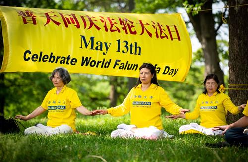 '图1~2:圣路易法轮功学员在当地著名景点森林公园集体炼功,庆祝法轮大法日。'