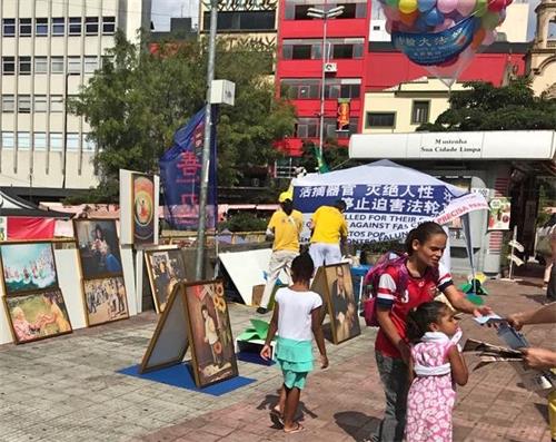 '图11:在圣保罗市,法轮功学员于五月十三日这天,在亚裔区热闹地段设真相展位,传播大法的真相。'