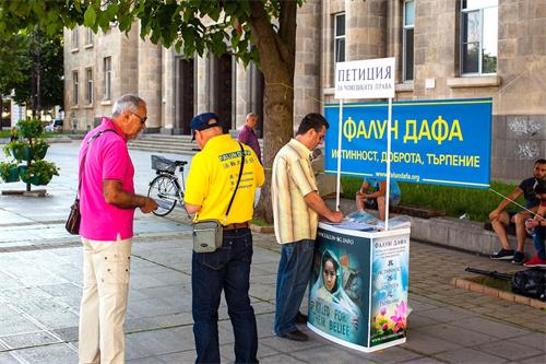 '图4:民众在征签表上签名'