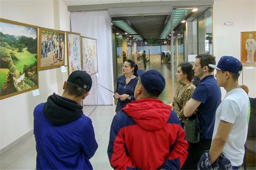 '图1~2:在俄罗斯克拉斯诺亚尔斯克市(Krasnoyarsk)的“真善忍美展”上,人们观赏画作,了解法轮功真相。'