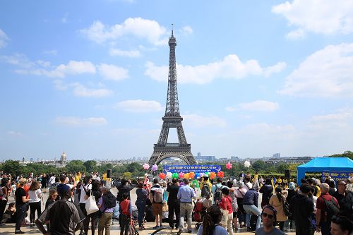 图3 :五月二十日,法国法轮功学员在法国巴黎人权广场庆祝法轮大法日,吸引过往的游客和法国民众驻足观看、拍照、摄像。