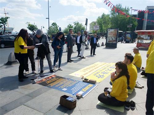 '图4:法轮功学员在海边广场炼功讲真相'