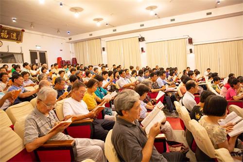 '图2:来自南台湾各县市炼功点的义务辅导员在大礼堂大组集体学法交流。'