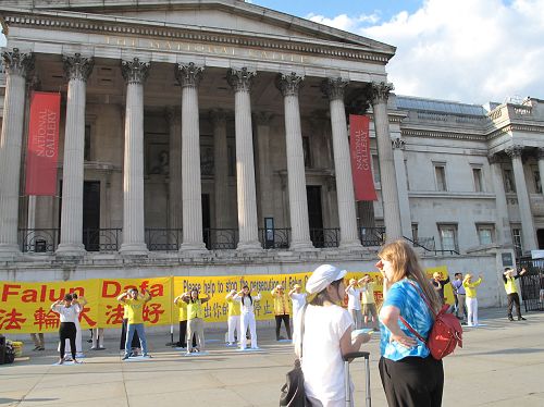 图4:二零一八年六月三日,在伦敦特拉法加广场,住在北英格兰、在星巴克公司工作的尼基•贝尔(右)向法轮功学员铭慧深入了解真相