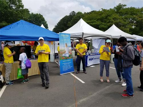 '图1:法轮功学员参加夏洛特亚洲节,向人们介绍功法'