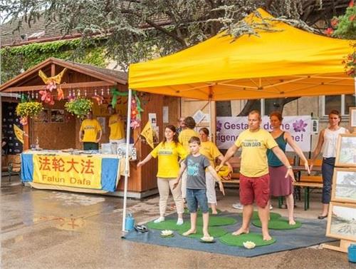 '图2:小男孩认真地跟法轮功学员学炼功法'