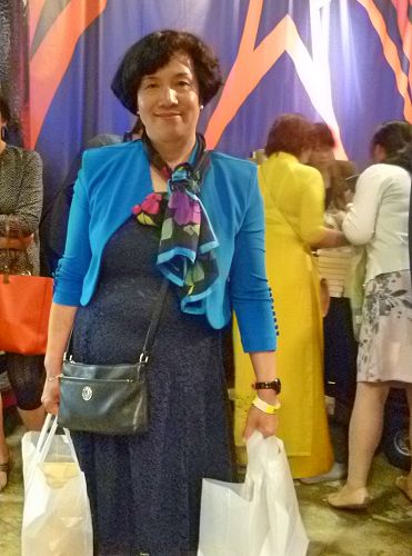 图3:来自瑞典的陈女士两手拿者刚刚购买的大法书,很高兴。